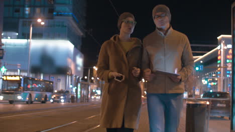 Young-modern-couple-with-tablet-PC-in-evening-city