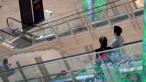 two people descending on an escalator together