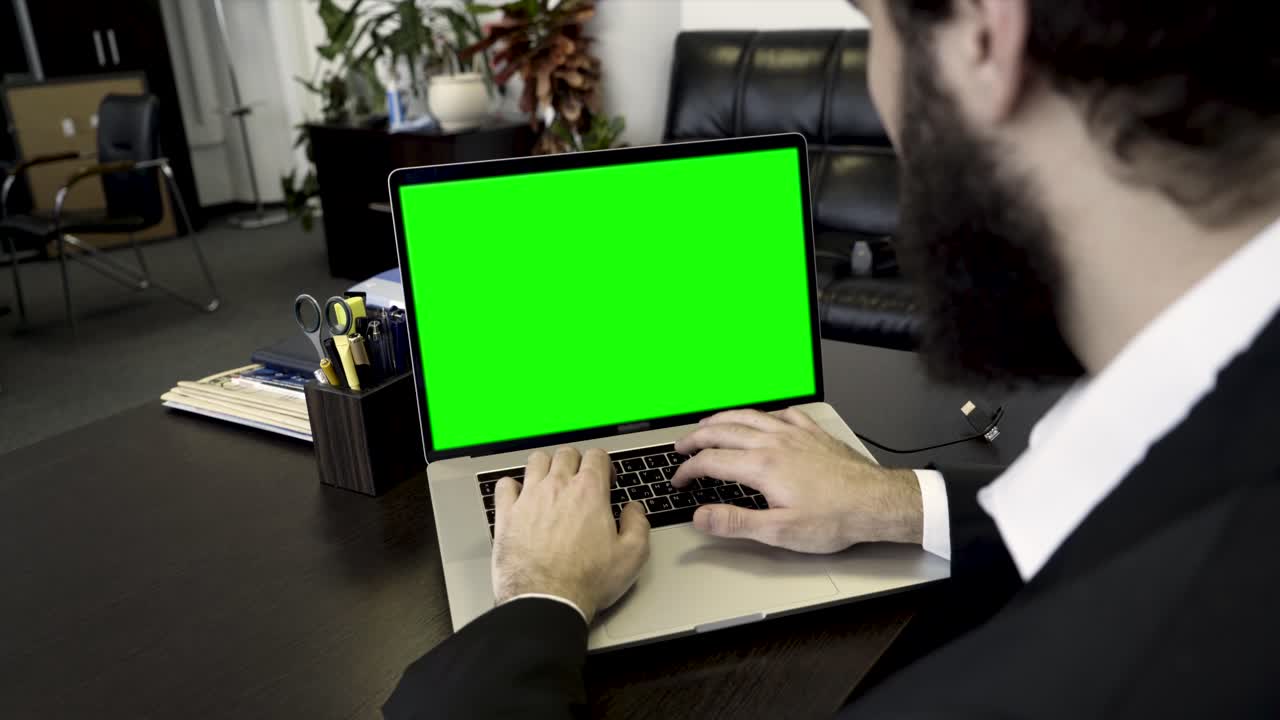 hombre de negocios trabajando en una computadora portátil con una pantalla verde
