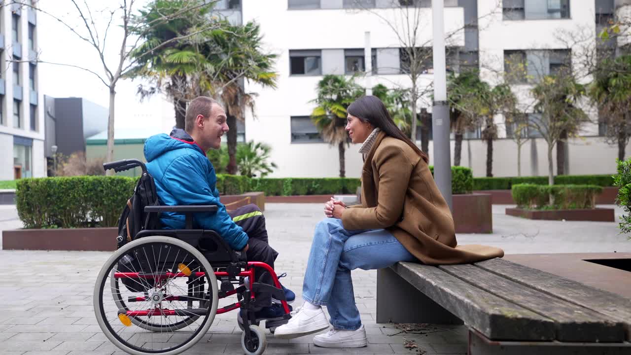 Conversazione tra una donna e un uomo in sedia a rotelle