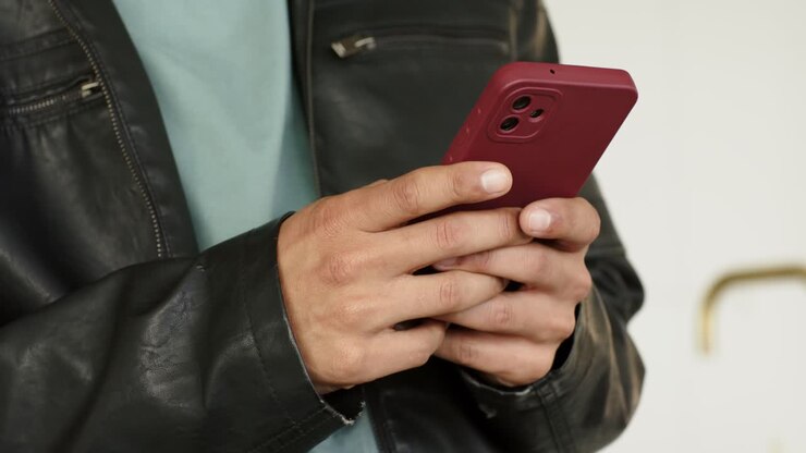 All'inizio, la persona sposta la presa per toccare e scorrere lo schermo rosso dello smartphone vicino al corrimano in ottone