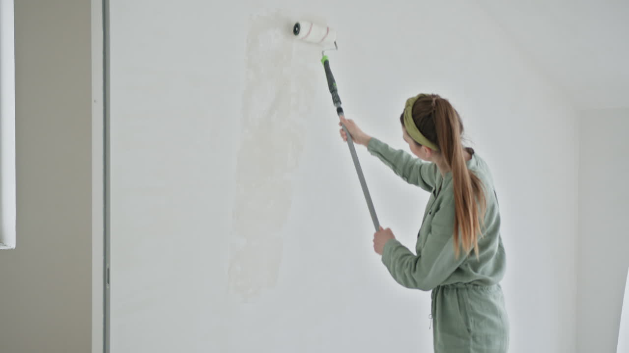 Una mujer pintando una pared.