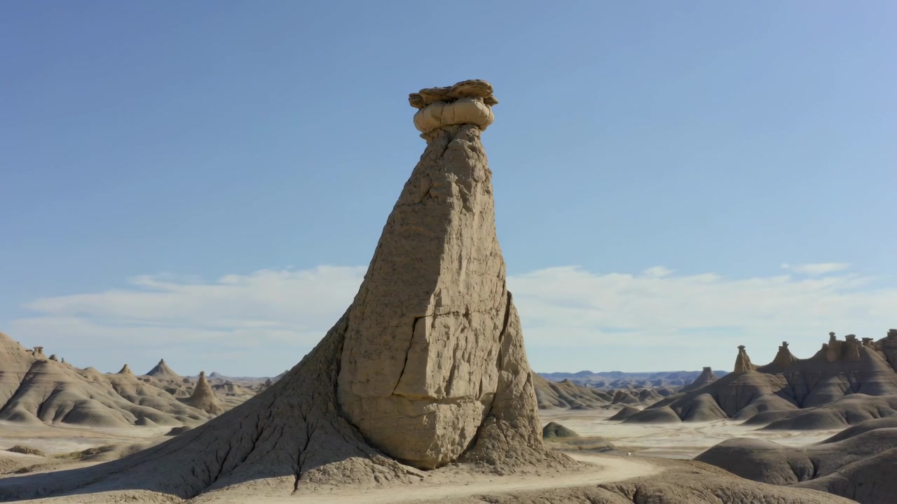 Kamera yavaşça yakınlaştırmaya başlıyor, çorak arazide sıkılaştırıp yeniden ortalayarak hoodoo şapka kayasını vurguluyor.