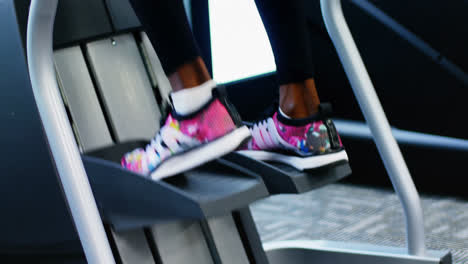 low-section of fit woman exercising on cross trainer