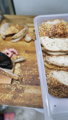 sliced bread in a container and hands holding bread slice