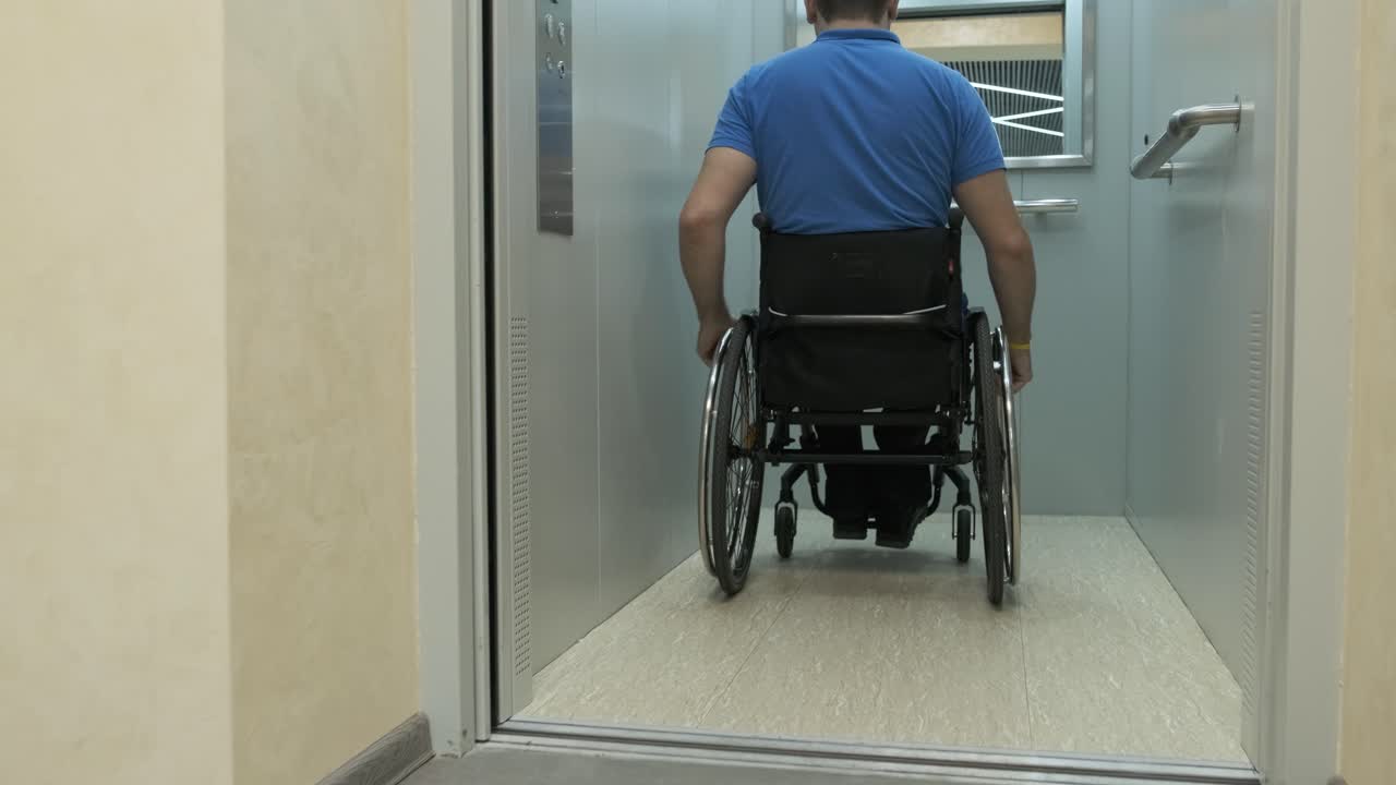 un hombre en silla de ruedas entra en el ascensor. una persona con discapacidad viaja en un ascensor.