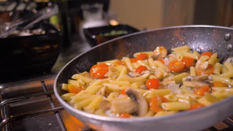 cooking delicious pasta with vegetables and mushrooms