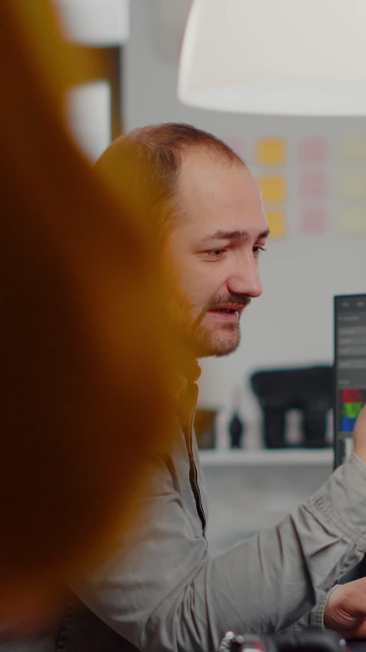 Vertical video Video editor talking on videocall holding smartphone