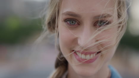 close up portrait cute young blonde woman smiling enjoying relaxed outdoors wind blowing hair slow motion feminine beauty