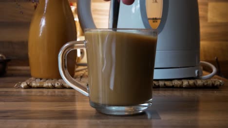 revolviendo una taza de café blanco instantáneo en primer plano lateral