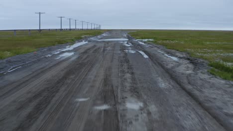 Luftdrohnenaufnahme,-Die-Tief-über-Aufgetautem-Tundra-Permafrost-Fliegt-Und-Die-Straße-In-Der-Nähe-Der-Arktis-In-Barrow,-Alaska,-überschwemmt