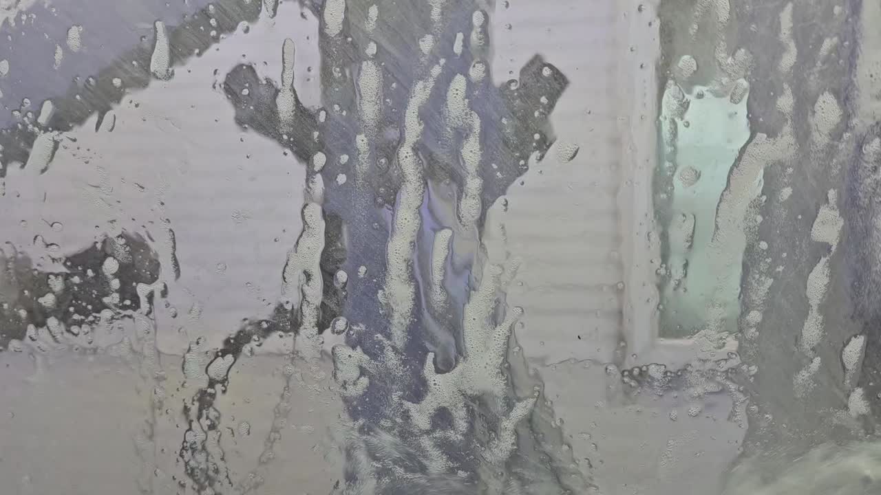 자동차 세탁 도중 앞 유리창 아래로 흐르는 물의 정적 시각