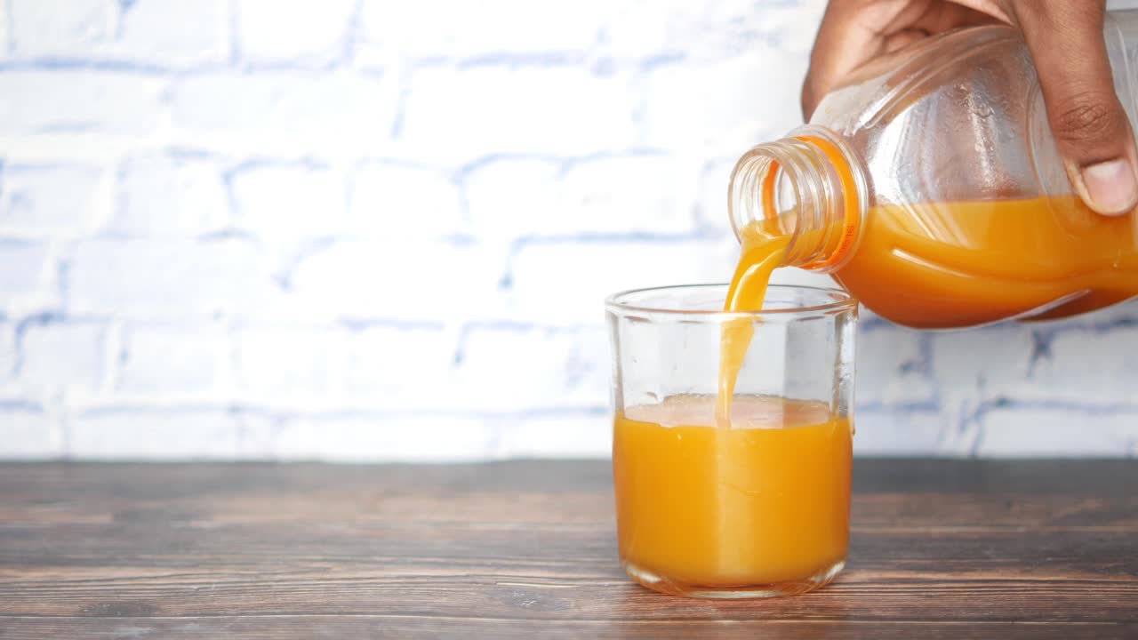 Versare il succo d'arancia in un bicchiere