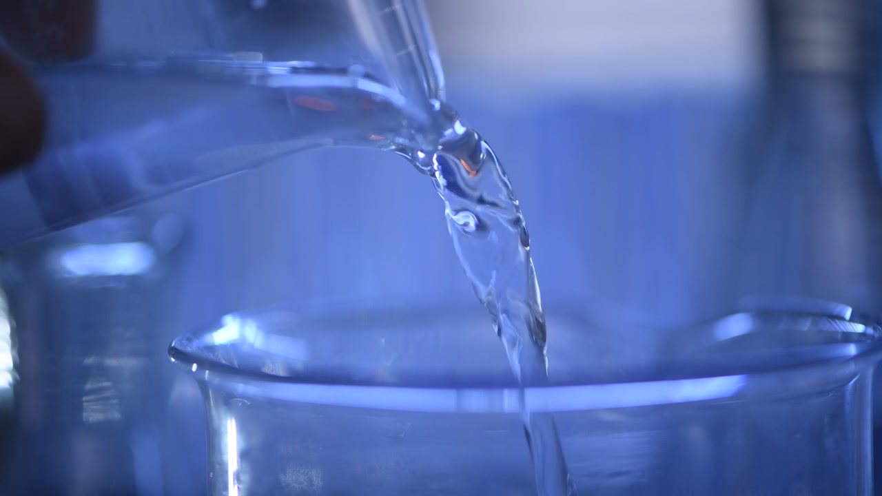 Clear Liquid Poured into a Glass Beaker in a Laboratory Setting
