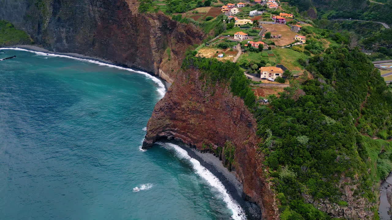 Edifici posizionati sulla costa rocciosa con vista aerea da drone sull'oceano. Piccolo insediamento