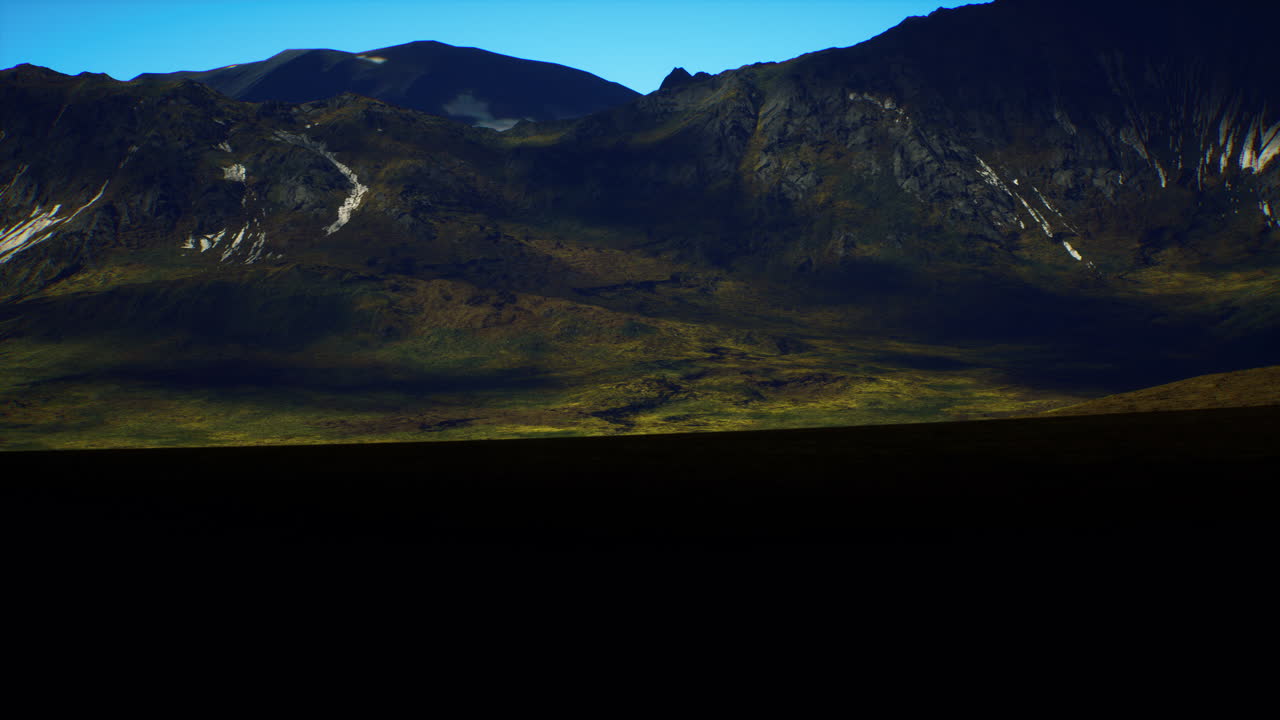 Vast landscape with mountains under clear blue sky at golden hour