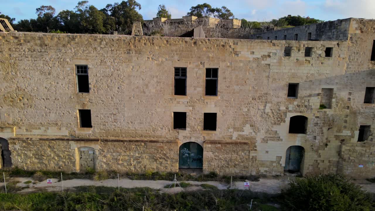 Vista ravvicinata da drone degli edifici abbandonati del Lazzaretto con muri in pietra consumati sull'isola di Manoel a Malta