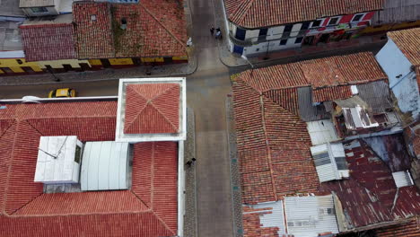 Toma-Aérea-De-Establecimiento-Mirando-Hacia-Abajo-De-Un-Barrio-Con-Techo-De-Tejas-Rojas-En-Bogotá,-Colombia-1