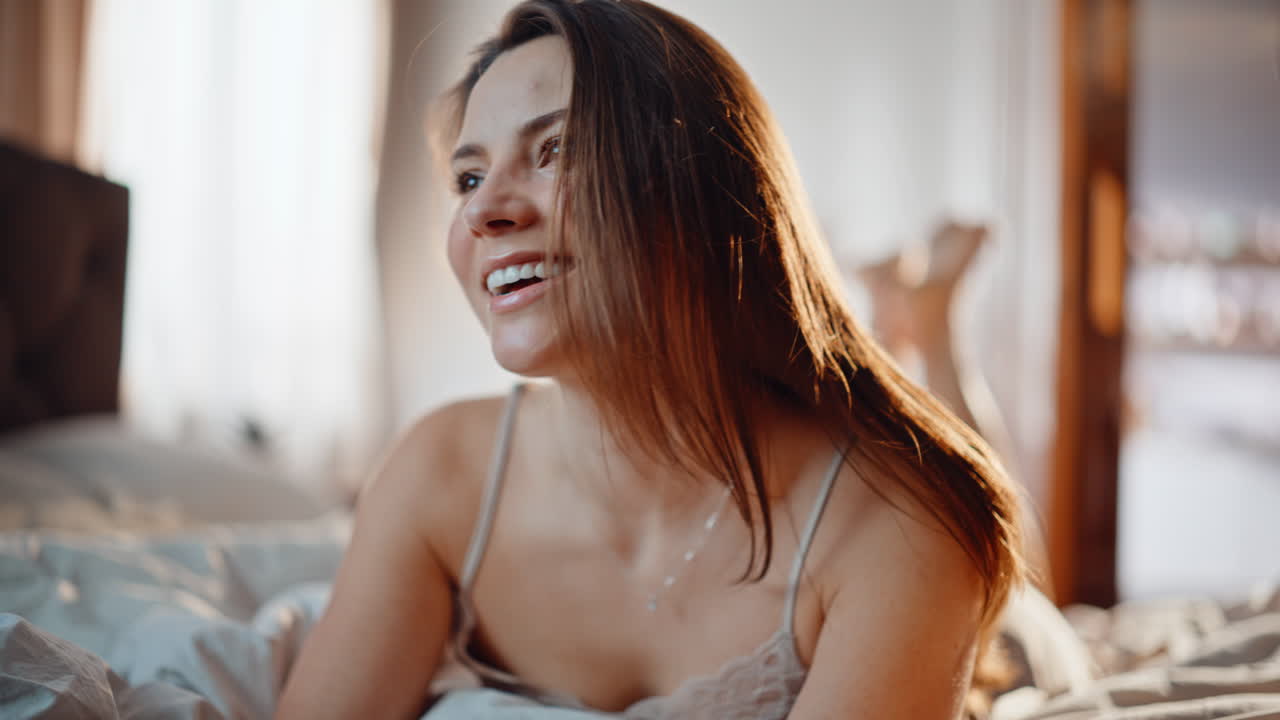 Morning girl watching social media on smartphone lying bed apartment closeup