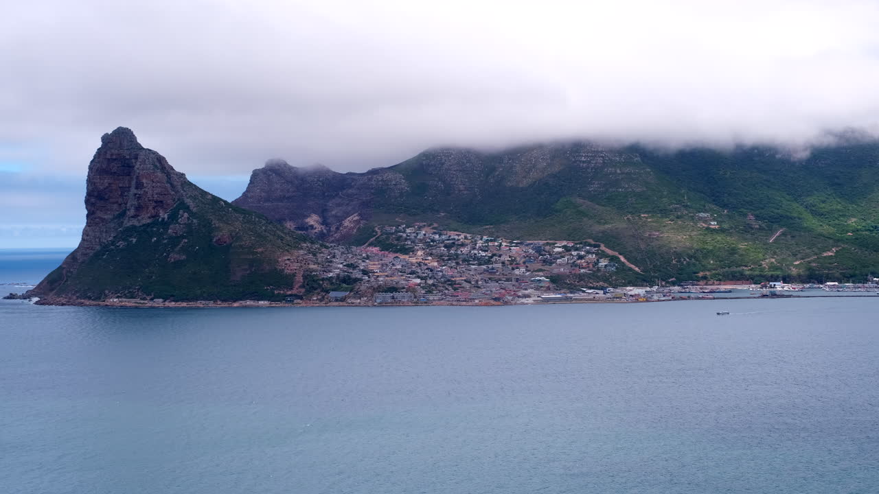 High angle view over bay towards The Sentinel, harbor and Hangberg in Hout Bay