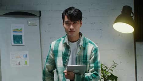 young asian man in office with tablet