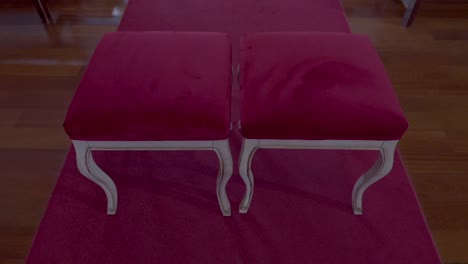 red velvet stools on wooden floor in elegant indoor setting