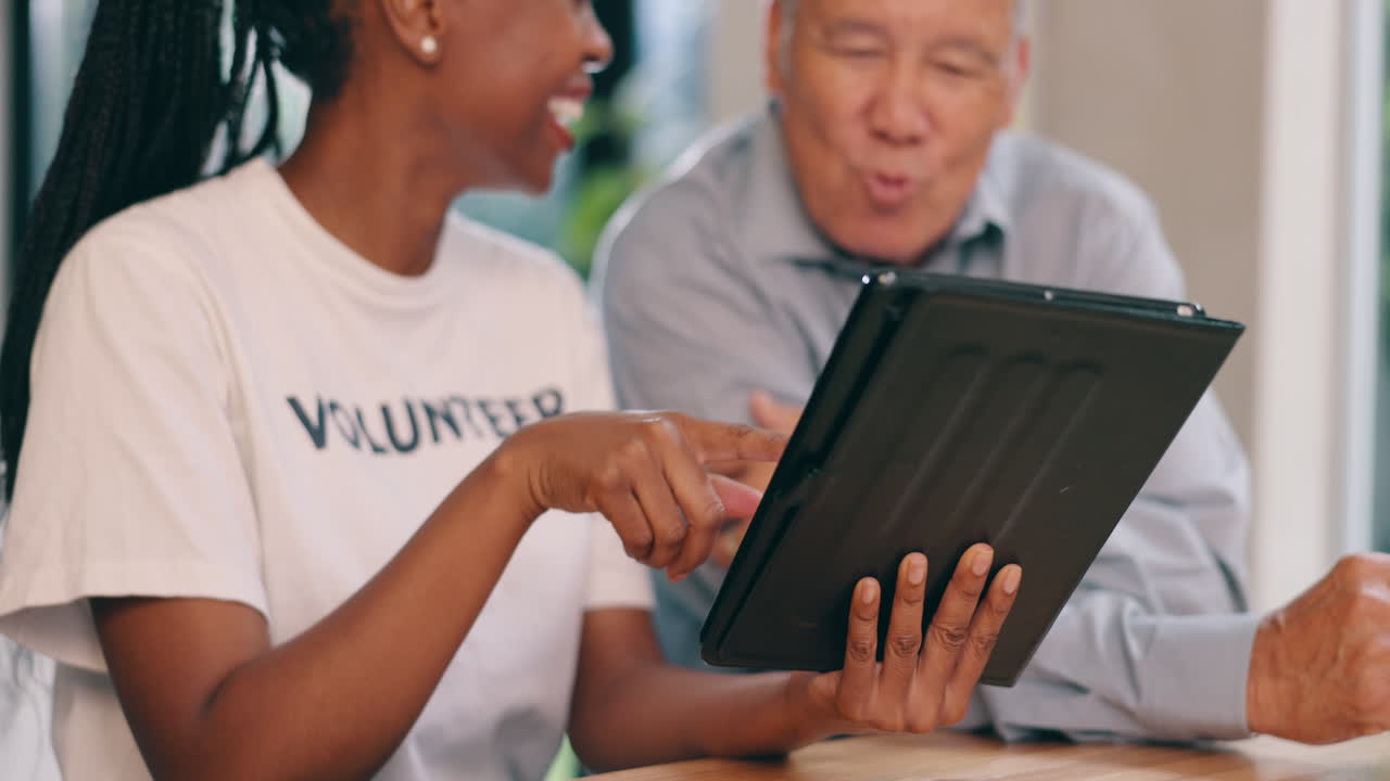 voluntario ayudando a un anciano con una tableta