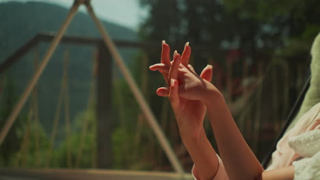 intertwined fingers of mother and little daughter in morning sunlight. family holds hands resting on lovely sunny day. concept of loving mother taking care of tiny toddler