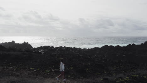 woman tourist exploring ponta da ferraria's rugged coastline in azores