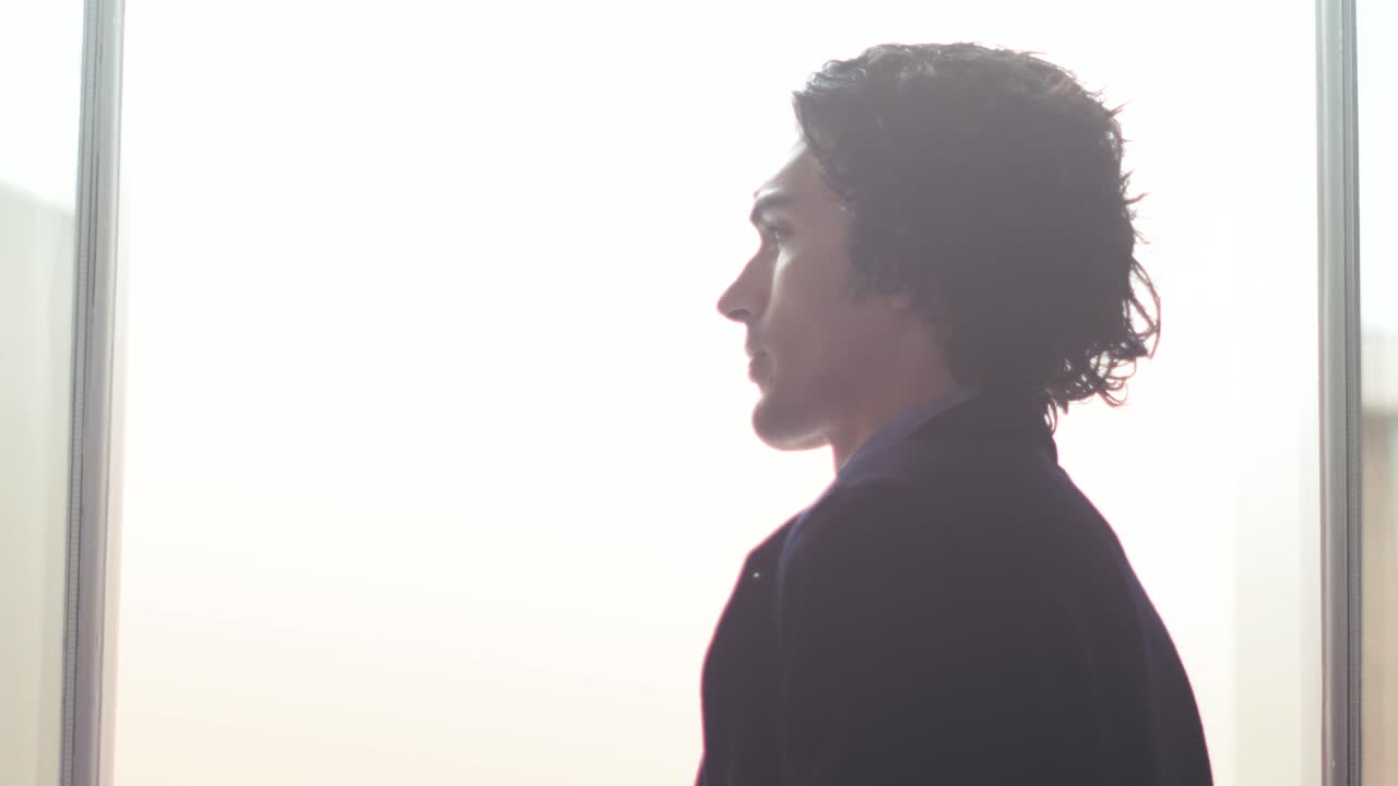 Man looking out window in bright minimal soft light