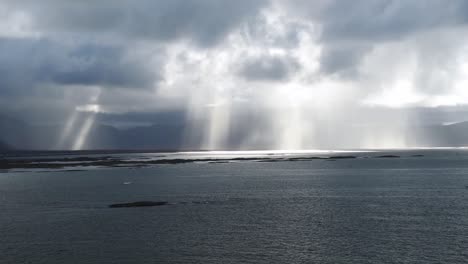 capa de nubes sobre el océano con áreas de lluvia visible en la distancia con rayos de sol