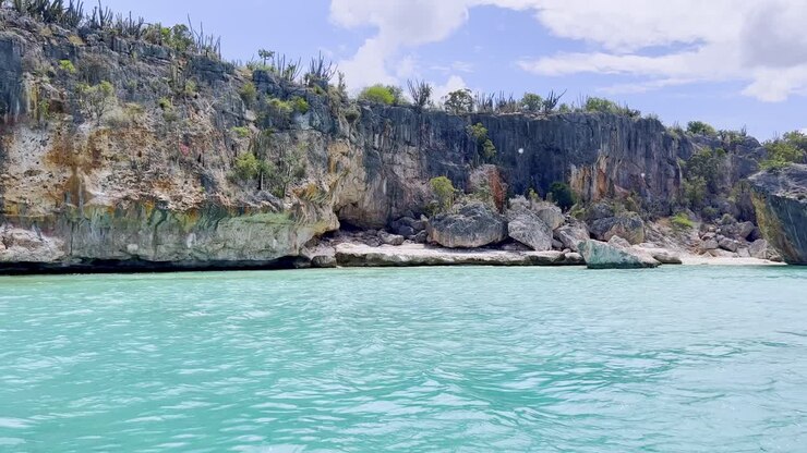 Pov shot of boat showing CABO ROJO PEDERNALES cliffs and splashing water during sunny day