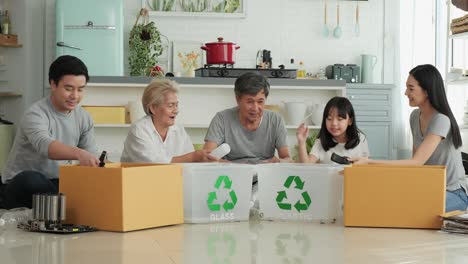 asian family helping to separate plastic bottle into recyclable bin at home together.