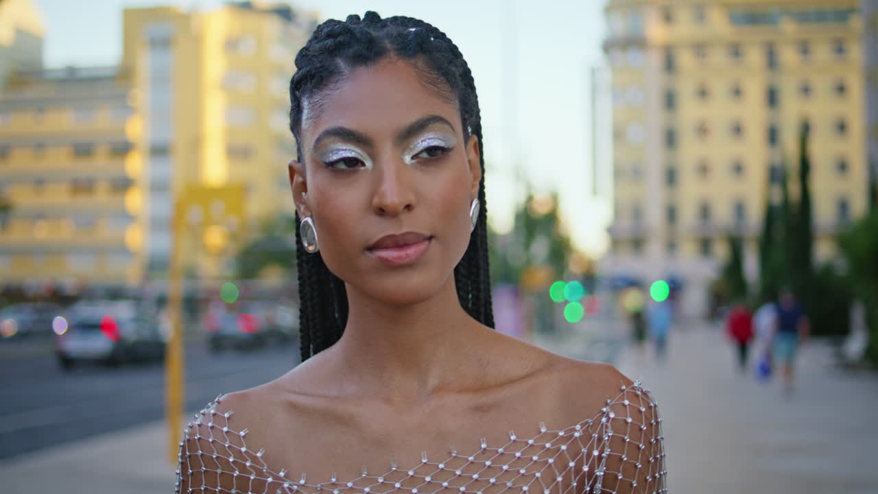 Primo piano di ragazza alla moda che passeggia in città al tramonto. Ragazza con i dreadlocks che si gode l'atmosfera urbana.