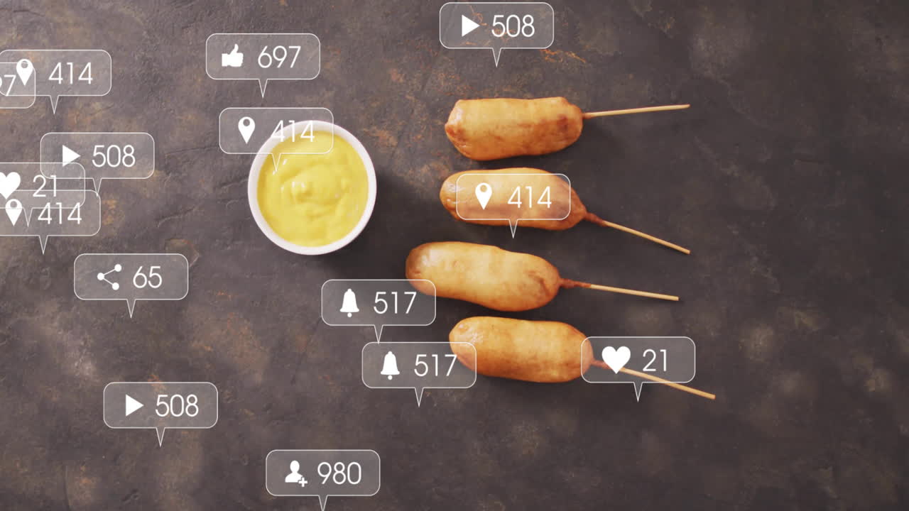Animation of corn dogs with mustard surrounded by social media icons