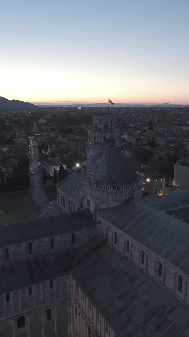Cinematic sunrise drone footage of the Leaning Tower of Pisa and the Piazza dei Miracoli, captured with smooth aerial movements and soft early morning light
