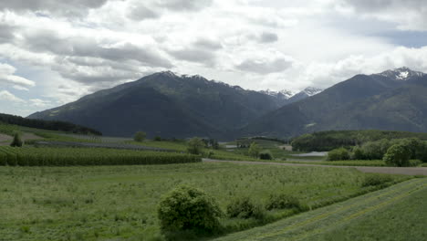 Lush-alpine-meadows-of-Dolomites-valley-serene-panorama,-aerial-view