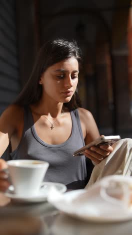 woman using phone in a cafe