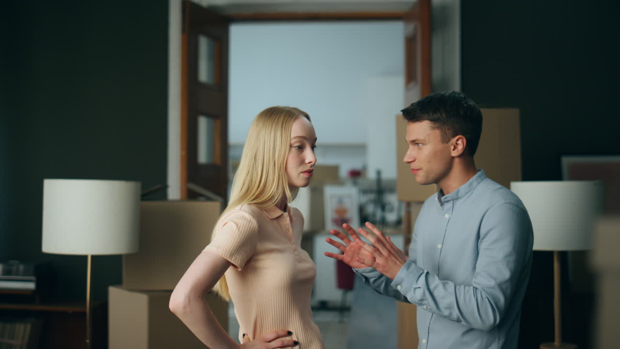 Millennial couple discussing disagreement at home gesturing emotionally close up