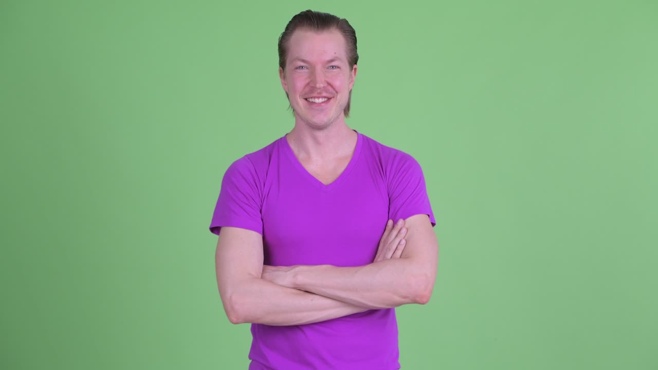 녹색 배경에 팔을 고 미소 짓는 젊은 남자의 스튜디오