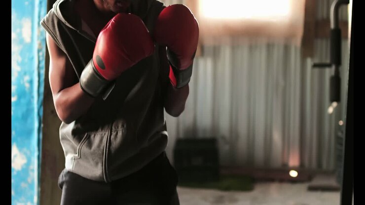 Pugile afroamericano che si allena nella boxe con un allenatore in una palestra 4K