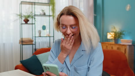 woman excitedly looking at phone