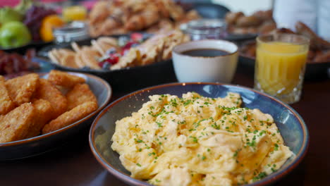 buffet of breakfast food, including eggs, coffee, juice, bacon and potatoes