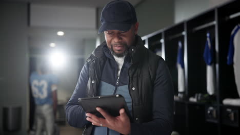 coach using tablet in locker room