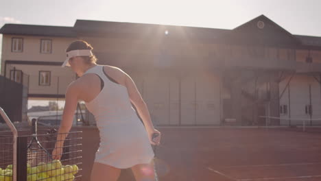 Tennisspielerin-Kommt-Auf-Den-Platz,-Nimmt-Den-Ball-Aus-Dem-Korb,-Konzentriert-Sich-Und-Schießt-Auf-Den-Ball.-Tennis-Zubehör.