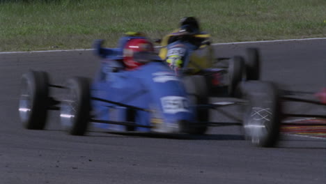 several cars race around a sharp turn