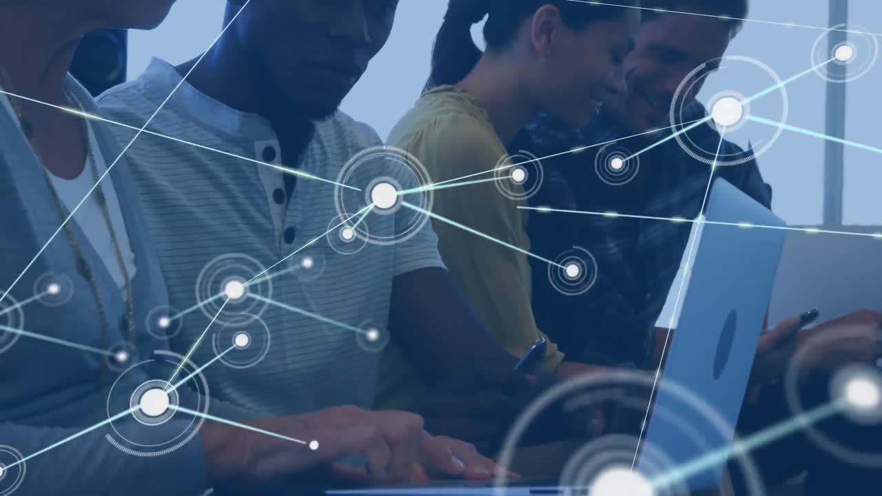 Animation of network of connections against diverse man and woman discussing over a laptop at office