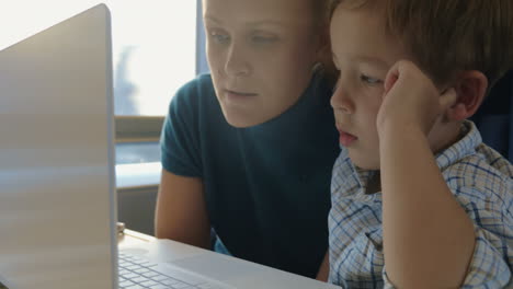 Madre-E-Hijo-Frente-A-Una-Computadora-Portátil-En-El-Tren