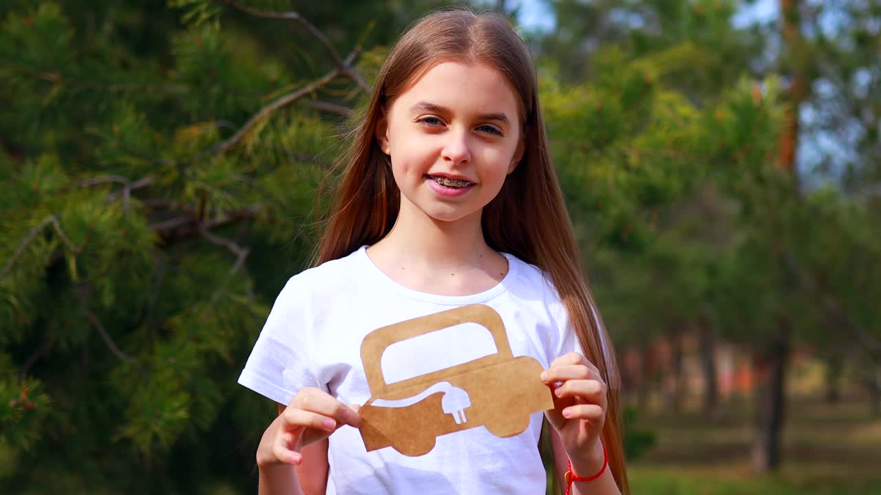 niña con creatividad artesanía pasatiempo coche de papel medio ambiente, ecológico, ahorrar energía en el parque en el día de verano