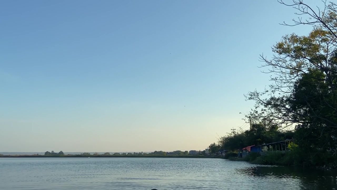 ทิวทัศน์ทะเลสาบอันเงียบสงบพร้อมท้องฟ้าสีครามสดใสและนกที่กำลังบิน